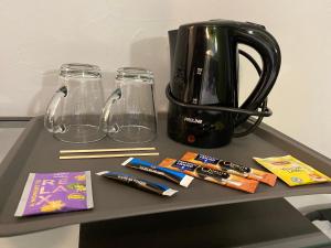 a table with a coffee pot and some toothbrushes andcils at H&ocirc;tel Bagatelle in Pont-&agrave;-Mousson