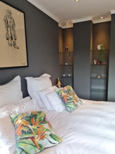 a bedroom with a white bed with two pillows at Oregon Apartment Cape Town in Cape Town