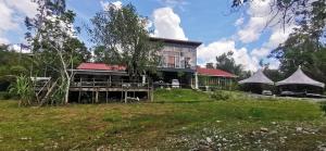 Badul Homestay في Musi: منزل بسقف احمر على ارض خضراء