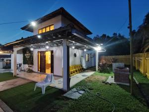 une petite maison avec un patio la nuit dans l'établissement Melaka AFamosa Pool Villa 5 Bedroom Moments Villa Lot 1319 Homestay, à Kampong Pulau Sebang