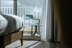 - une chambre avec un lit et une chaise sur un balcon dans l'établissement Ta' Tereza In Manwel Dimech, à Sliema