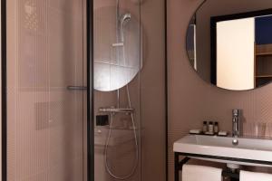 un bagno con doccia, lavandino e specchio di Paris Art Hotel Quartier Latin by Malone a Parigi