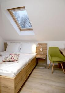a bedroom with a bed and a desk and a window at Pansion Legrađanka in Legrad