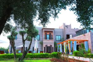 un edificio con sombrillas delante en Le petit Château des Anges, en Marrakech