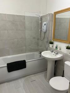 a bathroom with a sink and a tub and a toilet at The Holt in Leicester