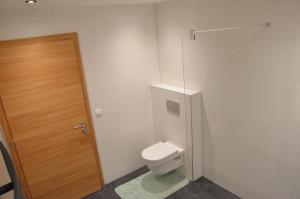 Un baño con inodoro y puerta de madera. en Apart Anna, en Pfunds