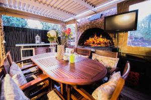 a table and chairs in a room with a fireplace at Cottonwood Guesthouse Oasis in Bloemfontein