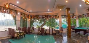 a restaurant with a pool table in a room with windows at Srina Forest Roar, Corbett- Near Pick up point in Rāmnagar