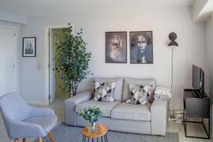ein Wohnzimmer mit einem Sofa und einem TV in der Unterkunft Apartamento Playa Lago in A Coruña