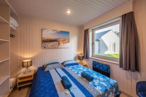 una piccola camera con letto e finestra di Bungalow Westende Blue a Middelkerke