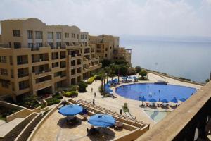 Spacious apartments with Sea view at Samarah Resort في السويمة: اطلالة على مسبح مع مظلات ومباني