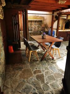 una mesa de madera y sillas en una habitación en The cave apartment, en Potamitissa