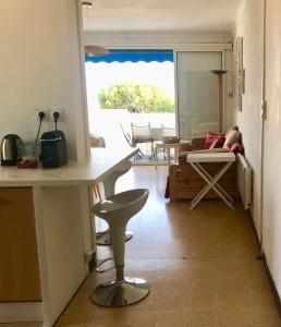 a kitchen and living room with a table and a couch at Les pieds dans l'eau : grand T2 avec garage in La Ciotat