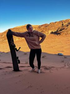 Una donna sta in piedi accanto a uno skateboard nel deserto di Wadi Rum Desert Adventures a Wadi Rum
