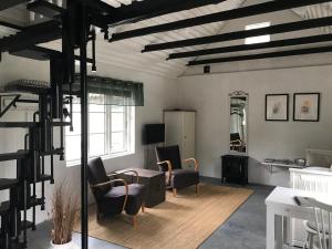 ein Wohnzimmer mit Stühlen und einem Tisch in der Unterkunft Stallet på Skårby in Ystad