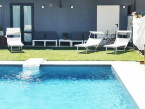 a group of chairs sitting next to a swimming pool at Locazione Turistica Dal Degan in San Bonifacio