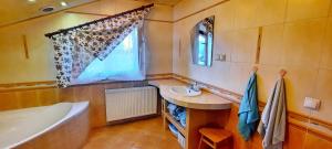 a bathroom with a tub and a sink and a bath tub at Chata u Górala in Stróża +2 photos
