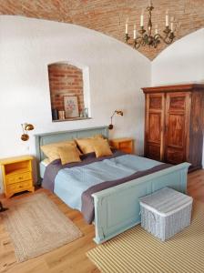 een slaapkamer met een blauw bed en een bakstenen muur bij 400 Éves Ház Vendégház in Kőszegszerdahely