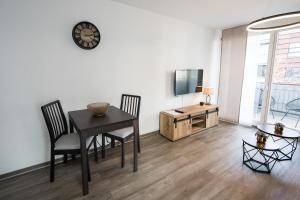 uma sala de jantar com uma mesa e cadeiras e uma televisão em Stylisches Apartment im Herzen von Dresden + Parkplatz + Netflix + Self Check-in em Dresden