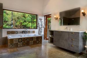 a bathroom with a large tub and a large window at Private Terrace Room with the most scenic views in Alibaug