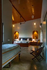 a bedroom with two beds and a table and chairs at Private Terrace Room with the most scenic views in Alibaug