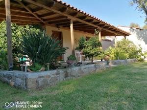 a porch of a house with plants in a yard at Litsa's House Platanias in Agia Paraskevi