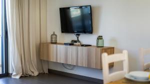 a television sitting on top of a wooden cabinet at Lake Apartment - Pool and Sea View & Tennis Court & BBQ & A Vilita in Pêra