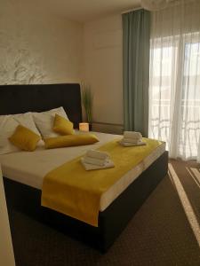 a bedroom with a large bed with two towels on it at Hotel Bor in Krk
