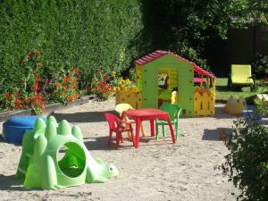 - une aire de jeux avec une table et des chaises dans le sable dans l'établissement Le Clos Robinson, à Martin-Église