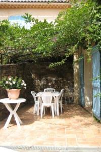 een patio met een tafel en stoelen bij Saint Joseph in Grimaud