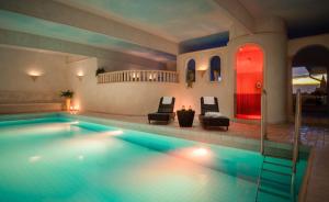 a swimming pool with two chairs and a red door at Ringhotel Winzerhof in Rauenberg