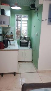 a kitchen with green walls and a white counter top at Mansholl Luxurious Apartment in Freetown