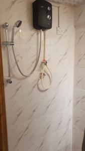 La salle de bains est pourvue d'une douche avec un pommeau de douche. dans l'établissement Mansholl Luxurious Apartment, à Freetown