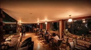 a group of people sitting at tables in a restaurant at Regency Hotel in Cairo