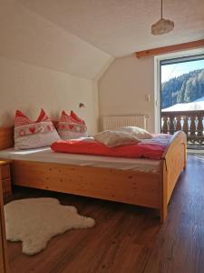 drewnianym łóżkiem w pokoju z oknem w obiekcie Ferienhütte Antonia w mieście Kliening