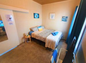 - une petite chambre avec un lit et une table dans l'établissement WOODY Pt - AMAZING 1970's SHARE HOUSE BY THE SEA-3 rooms available!, à Woody Point
