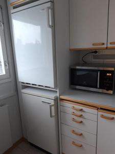 uma cozinha com um frigorífico e um micro-ondas em Viihtyisä yksiö Oulun Tuirassa em Oulu