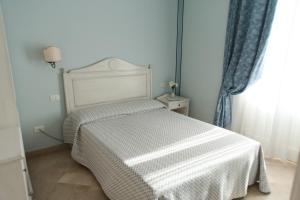 a bedroom with a bed with a white comforter at Relais Antiche Saline in Torre Nubia