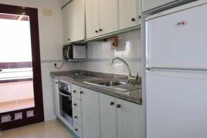 eine kleine Küche mit Spüle und Kühlschrank in der Unterkunft 29a zafiro 1ª línea de playa in Calpe