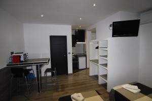 Habitación pequeña con escritorio y cocina con encimera. en Hostal MH Fuencarral, en Madrid