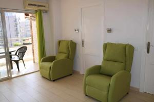 twee groene stoelen in een kamer met een raam bij 1B Mar II 1 dormitorio con vistas al mar in Calpe