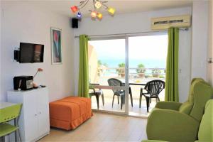 een woonkamer met een tafel en stoelen en een balkon bij 1B Mar II 1 dormitorio con vistas al mar in Calpe