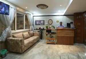a man sitting at a desk in a living room at Villa Residency in Navi Mumbai