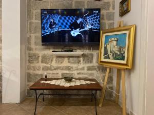 uma sala de estar com televisão numa parede de tijolos em Apartment Saraka em Dubrovnik