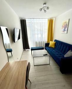 sala de estar con sofá azul y mesa en GWAREK Centrum Wypoczynkowe en Ustroń