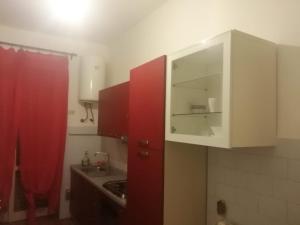 a kitchen with red cabinets and a red curtain at Galeazzi private house Milano in Milan