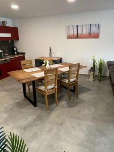 a dining room with a wooden table and chairs at Ferienwohnung an der Reitanlage in Glashütte