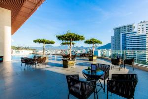 un patio con tavoli e sedie sul tetto di Muong Thanh Luxury Vien Trieu Nha Trang a Nha Trang