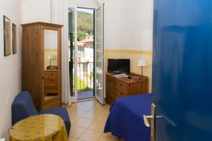 1 dormitorio con 1 cama, TV y ventana en Hotel Sette Archi, en Bocca di Magra