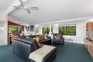 Opua的住宿－Breezy on Broadview - Opua Holiday Home，客厅配有真皮沙发和椅子